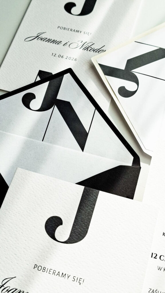 Minimalistyczne zaproszenia z czarnymi inicjałami – detal typografii